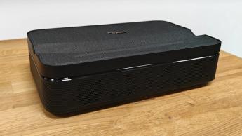 Портативный ультракороткофокусный проектор Optoma Photon Go на деревянном столе под небольшим углом