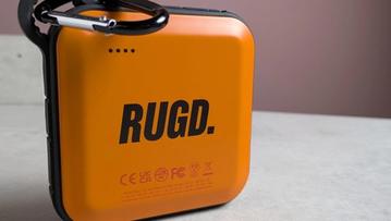 RUGD Power Brick bærbar oplader på et skrivebord med pink baggrund