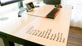 Persona utilizando un escritorio con superficie de pizarra blanca en el escritorio elevable Uplift V2