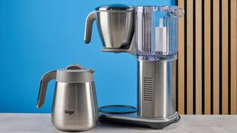 La macchina da caffè Breville Luxe con caraffa termica in metallo argentato, cestello del filtro, serbatoio dell’acqua in plastica rimovibile e manopola per il controllo dell’estrazione, mostrata con diversi cestelli e filtri di carta