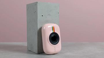 Vrurc t6s bærbar powerbank stående på en hvid platform på et skrivebord med lyserød baggrund
