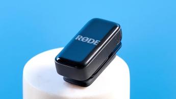 Das Rode Wireless-Mikrofonsystem mit schwarzem Ladecase und zwei schwarzen Sendern vor blauem Hintergrund