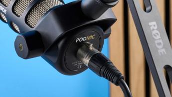 Das Rode PodMic Podcast-Mikrofon mit DS2-Tischständer vor blauem Hintergrund