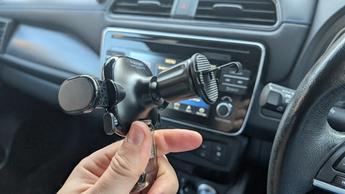 Suporte veicular universal Spigen onetap segurando um smartphone em um veículo