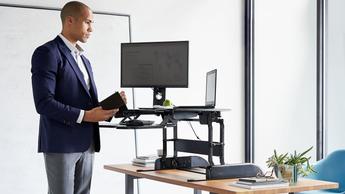 Un hombre trabajando en un escritorio ajustable en altura en una oficina