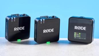 Rode Wireless GO Gen 3 Mikrofonsystem mit einem Empfänger, zwei Sendern und Zubehör wie Fell-Windschutz, Ladeanschlüssen und Kabeln auf blauem Hintergrund