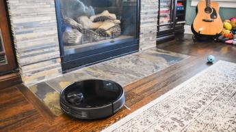 Robot aspirador Wyze navegando por suelos de madera junto a áreas con moqueta