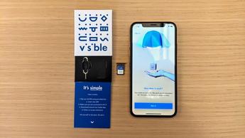 iPhone placeret ved siden af den synlige startpakke, der viser produktopsætningen