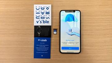 iPhone placeret ved siden af den synlige startpakke, der viser produktopsætningen