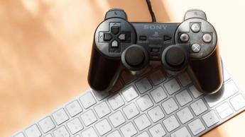 En PlayStation-controller, der ligger på et Mac-tastatur
