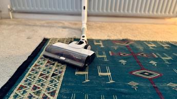 Cabezal flexible de la aspiradora inalámbrica Tineco Pure One A50S limpiando debajo de los muebles