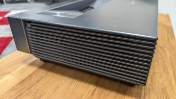 Вид сбоку на решётку ультракороткофокусного проектора Hisense PX3 на деревянном столе