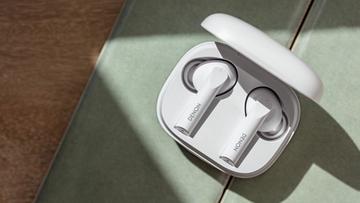 Denon AH-C840NCW ægte trådløse øretelefoner i hvid i deres ladeetui på grønt stof og trægulv
