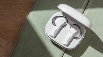 Denon AH-C840NCW ægte trådløse øretelefoner i hvid i deres ladeetui på grønt stof og trægulv
