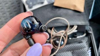 Campfire Audio Clara in-ear høretelefoner vist i hånden og båret af en kvinde