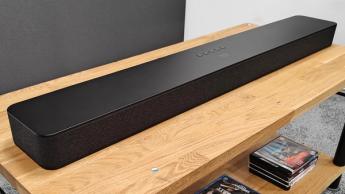 Amazon Fire TV Soundbar Plus Dolby Atmos soundbar on wooden AV rack slight side angle