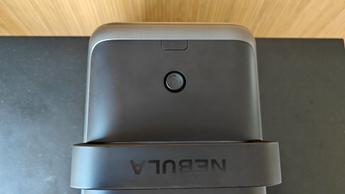 Вид сверху на домашний кинотеатр-проектор Nebula X1 с видимой кнопкой питания и фирменным логотипом Nebula