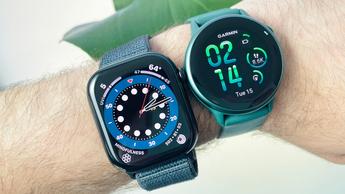 Close-up of a user's wrist wearing both the Apple Watch 10 on a blue fabric strap (left) next to the Garmin Vivoactive 6 (right) on an emerald green strap