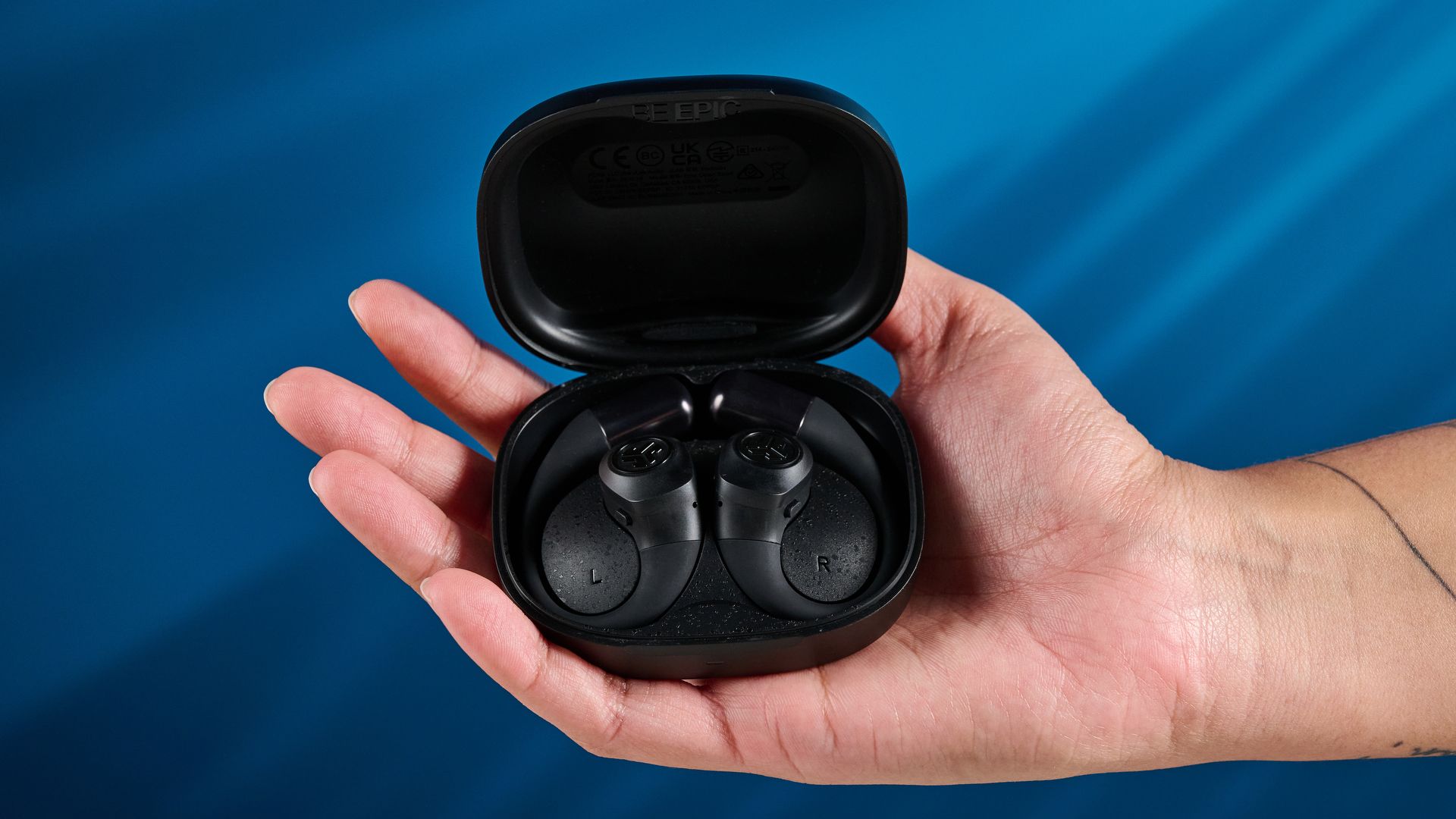 Jlab Epic Open Sport Open-Ear Wireless-Kopfhörer in Schwarz vor blauem Hintergrund