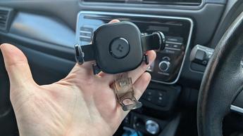 Suporte veicular universal Spigen OneTap segurando um smartphone no interior de um carro