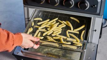 Freidora de aire y horno tostador Cuisinart TOA-60 con acabado en negro y controles de temperatura ajustables