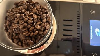 Vista superior de la cafetera De'Longhi Rivelia con granos de café en el depósito