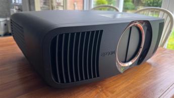 Домашний кинотеатр-проектор Epson EH-QB1000 на деревянном столе, вид слева