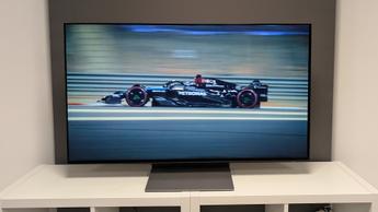 48-дюймовый OLED-телевизор Samsung S90F с изображением болида Формулы-1 на белой деревянной тумбе