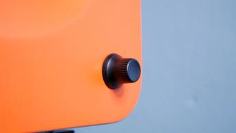 Nahaufnahme des orangefarbenen Kanto Ren Lautsprechers mit schwarzem Lautstärkeregler