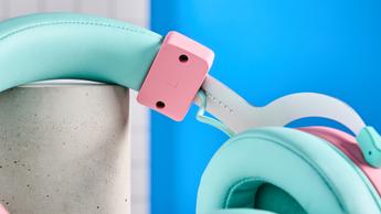 Ett rosa och turkost Cooler Master CH351 trådlöst gaming-headset på ett skrivbord