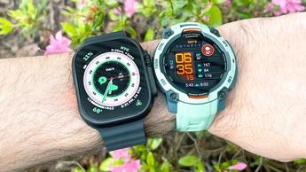 Close-up do Apple Watch Ultra 2 e Garmin Instinct 3 no pulso de uma pessoa, exibindo os seus designs e funcionalidades