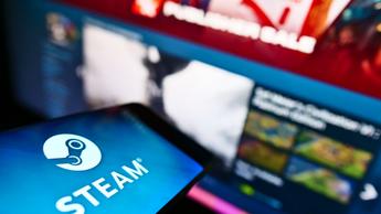 Mobiltelefon som visar Steam-appens logotyp från Valve framför den officiella Steam-webbplatsen