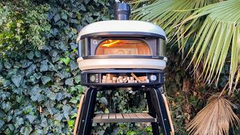 Un horno de pizza Gozney Dome para cocinar al aire libre en el jardín