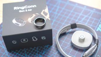 Nærbillede af Ringconn Gen 2 Air smart ring, som hviler på sin emballage med opladningsdock og kabel ved siden af