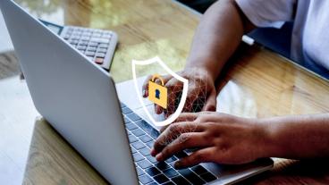 보안 자물쇠 아이콘이 표시된 노트북에서 작업하는 손