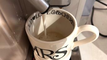 Cafetera De'Longhi Rivelia espumando leche en una taza de vidrio