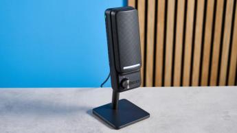 Nzxt Capsule Elite Gaming-Mikrofon in Schwarz mit zwei Reglern und RGB-Beleuchtung vor blauem Hintergrund