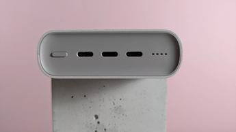 Nærbillede af porte på Samsung 45W 20.000mAh batteripakke på lyserød baggrund