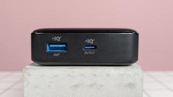 Close-up of ports on Anker 20,000mAh 87W Power Bank, on plinth on desk, with pink background