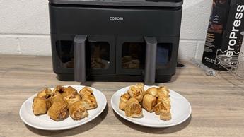 Enroladinhos de salsicha recém-assados em uma fritadeira elétrica Cosori de cesto duplo