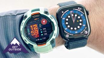 Primer plano de una muñeca con el Garmin Instinct 3 en color turquesa y el Apple Watch Series 10 con correa azul