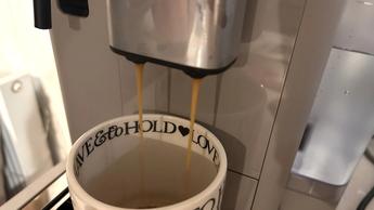 Cafetera De'Longhi Rivelia con dispensador de agua sobre una barra de cocina