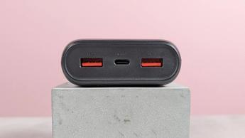 Nærbillede af VRURC 20.000mAh 20W powerbank-porte på en sokkel med lyserød baggrund