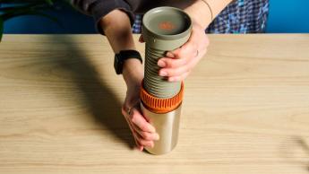 Cafeteira portátil Wacaco Pipamoka exibida sobre um fundo azul