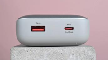 Vista en primer plano de los puertos del power bank Aukey Spark Mini 20000 sobre un pedestal con fondo rosa
