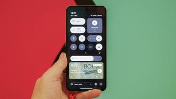 Person holder en CMF Phone 2 Pro-smartphone, der viser indstillinger og widgets på startskærmen
