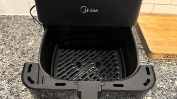 Freidora de aire Midea MAD53109APK de 5.5 litros con el cajón abierto sobre la barra de la cocina