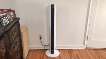 Calefactor y ventilador de torre Lasko FH500 sobre un suelo de madera