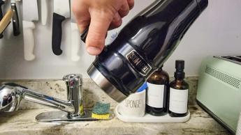 Best travel coffee mugs: Thermos mug shown above sink
