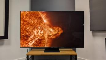TCL C855K 65-inch Mini LED TV on wooden AV bench with solar flare on screen
